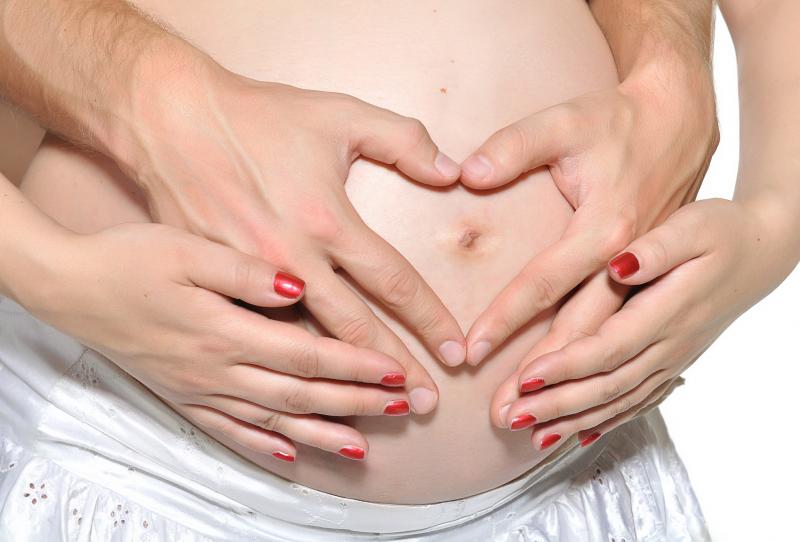 mãos de grávida sobre o ventre