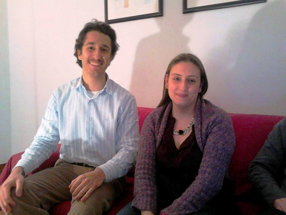 senhor e senhora sentados no sofá vermelho