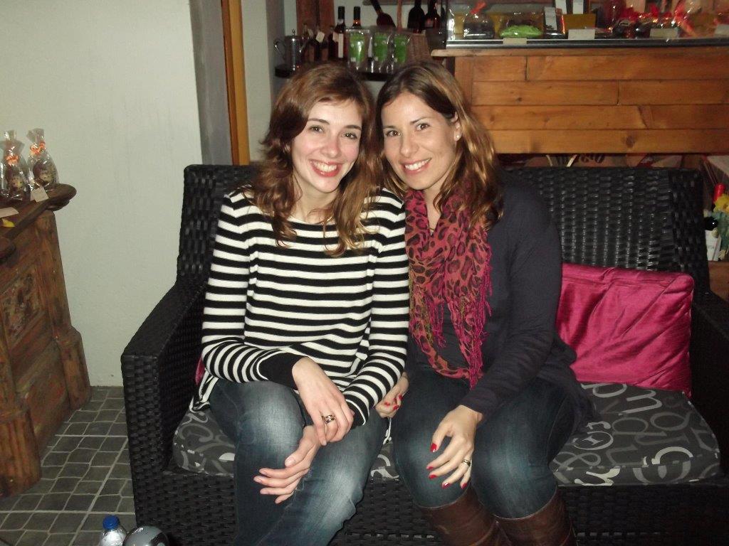 senhoras a sorrir sentadas no sofa preto