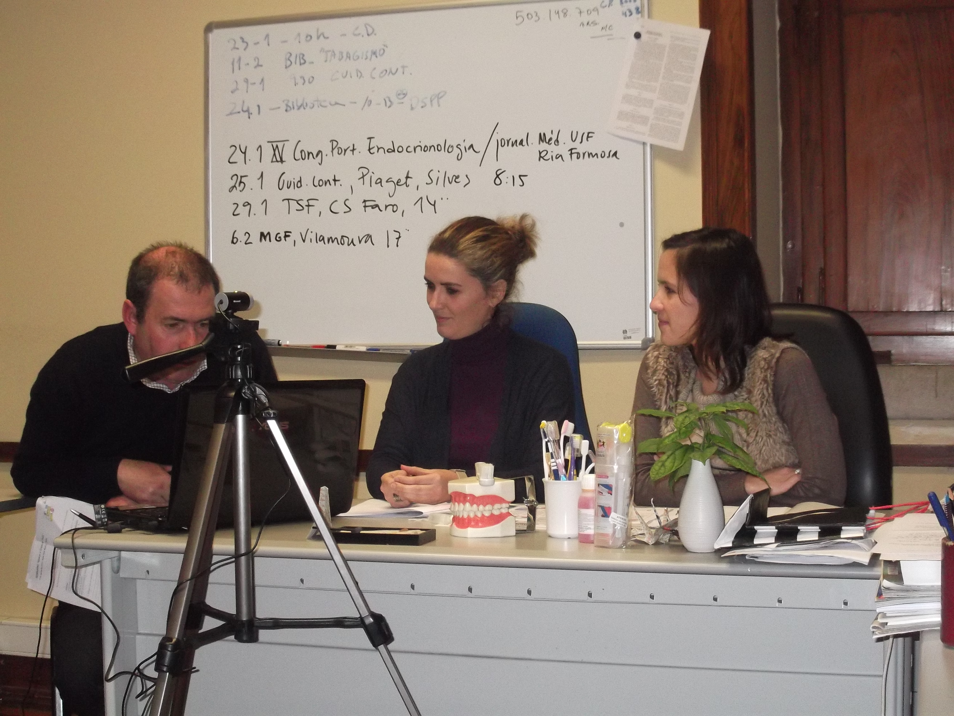 3 senhores a secretaria com quadro atras