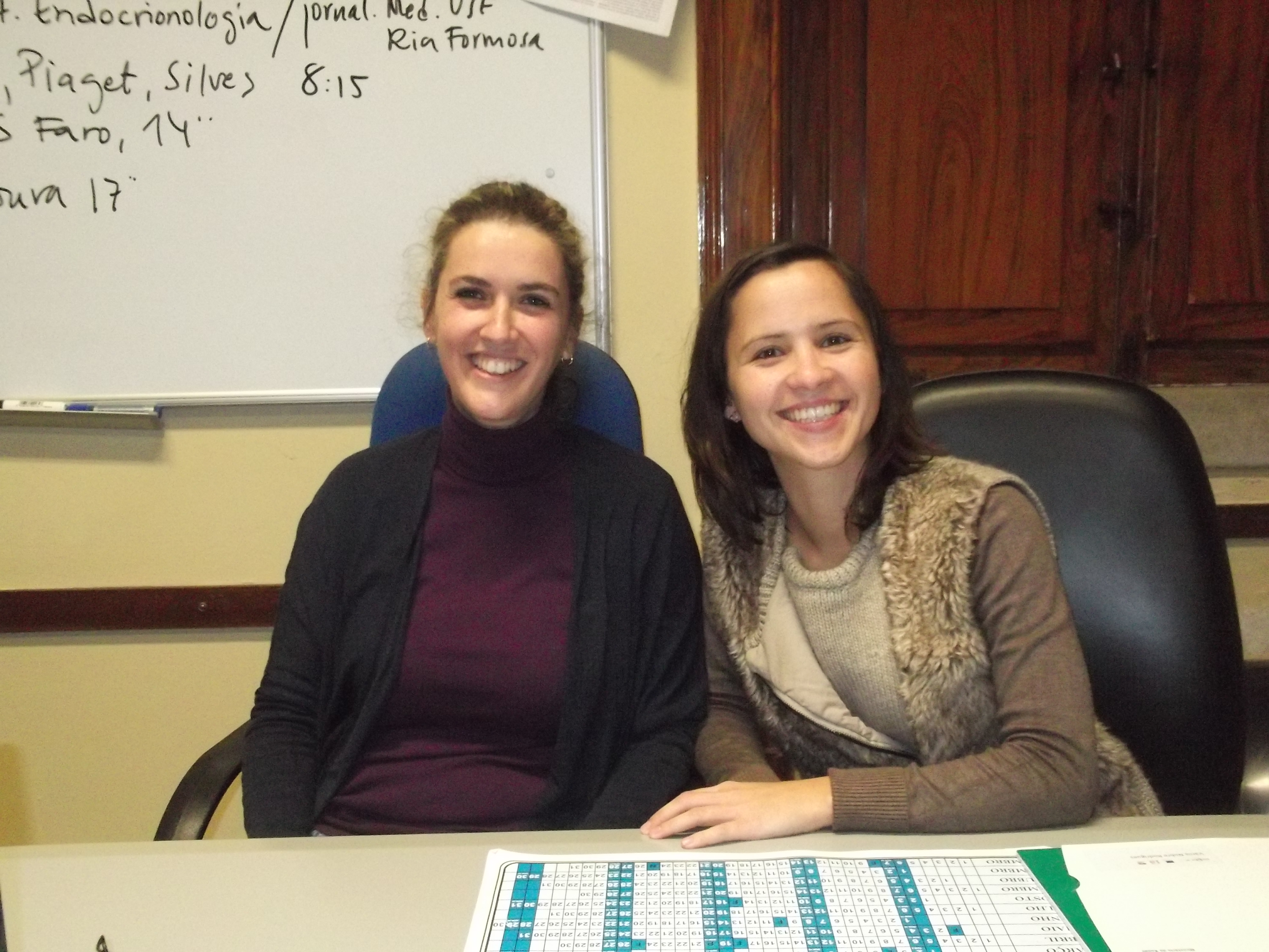 duas senhoras sentadas a mesa sorrindo