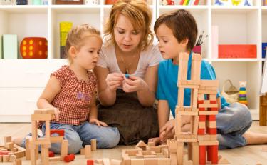 senhora mostra brinquedos ao menino e menina
