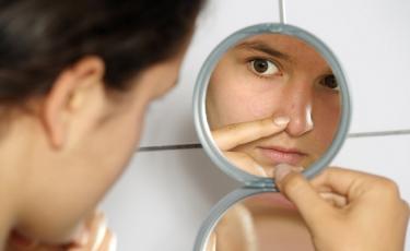 menina olha para o espelho redondo