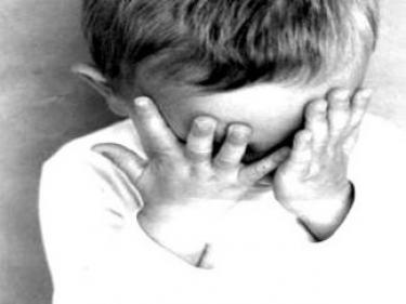 menino com duas maos na cabeca