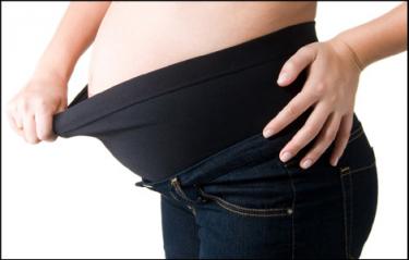 senhora grávida puxa o elástico de calças pretas