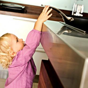 bebe tenta chegar a frigideira